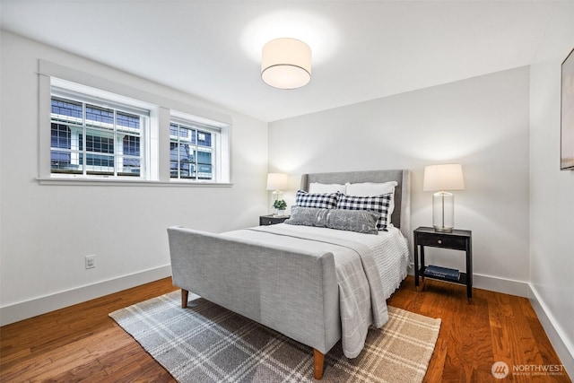 bedroom with baseboards and dark wood-type flooring