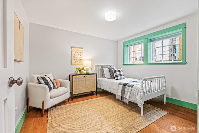 bedroom featuring baseboards and wood finished floors