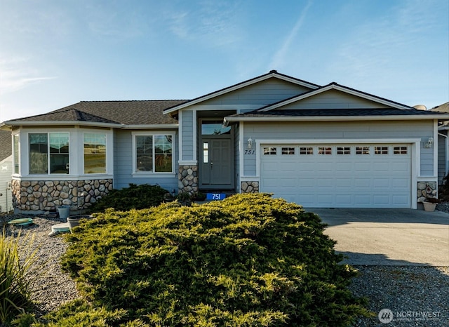 view of front facade featuring stone siding, an attached garage, and concrete driveway