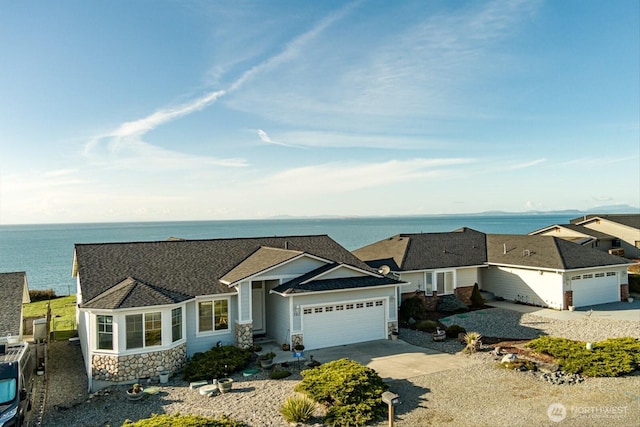 view of front of property featuring stone siding, an attached garage, and driveway