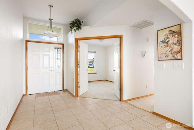 foyer entrance featuring visible vents, baseboards, and light tile patterned floors