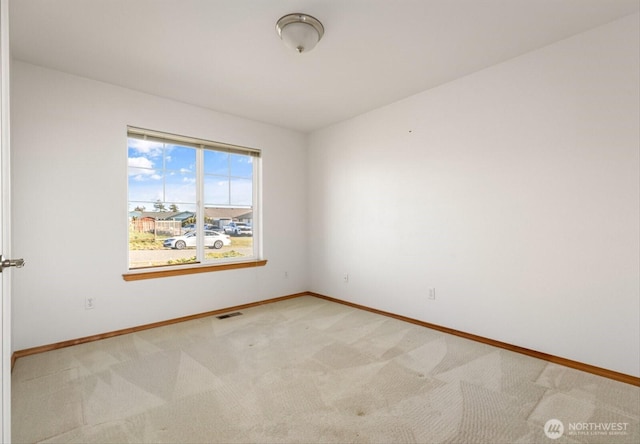 unfurnished room featuring light carpet, visible vents, and baseboards