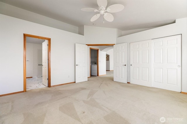 unfurnished bedroom with arched walkways, washer / clothes dryer, carpet flooring, and baseboards