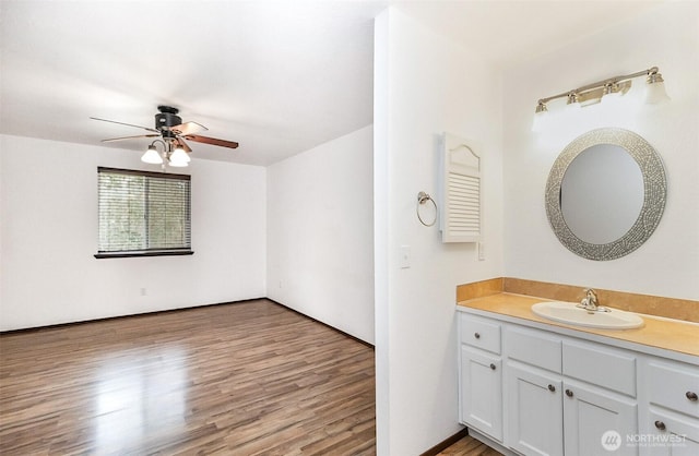 bathroom with ceiling fan, wood finished floors, and vanity