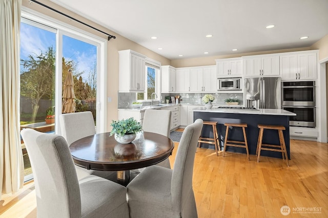 dining space with light wood-style flooring and recessed lighting