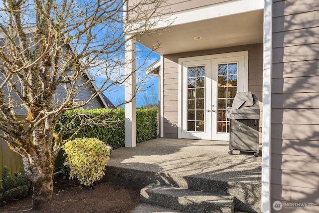 view of exterior entry with a patio area and french doors