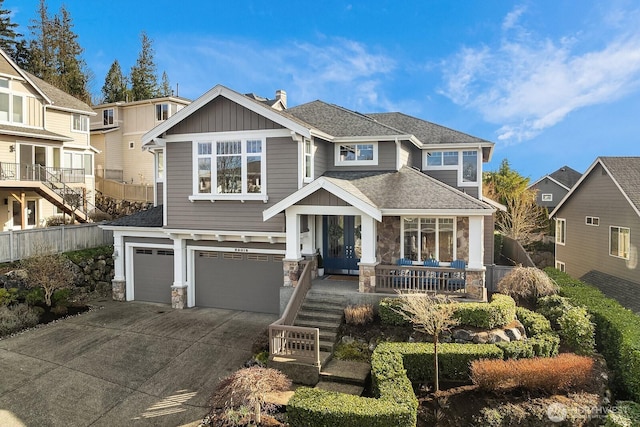 craftsman house with a garage, a shingled roof, concrete driveway, stone siding, and a porch