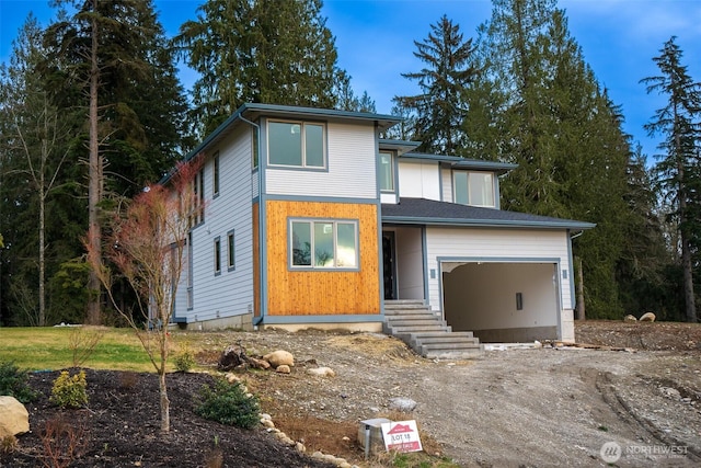 modern home with dirt driveway and a garage