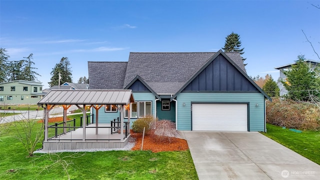 view of front of property featuring an attached garage, covered porch, and a front yard