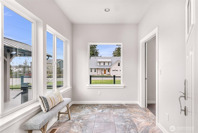 living area with baseboards, recessed lighting, and a healthy amount of sunlight