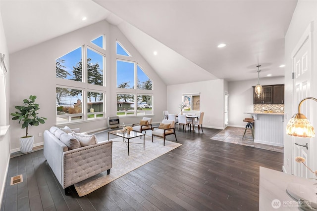 living area with baseboards, high vaulted ceiling, dark wood finished floors, and recessed lighting