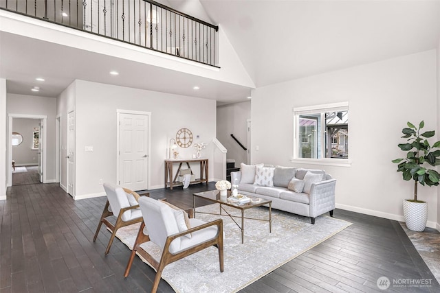 living room featuring high vaulted ceiling, stairway, baseboards, and dark wood-type flooring