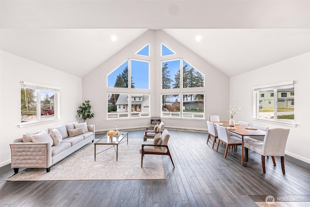 living room with dark wood-style floors, high vaulted ceiling, plenty of natural light, and baseboards