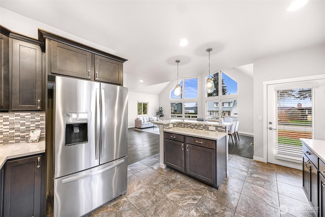 kitchen with tasteful backsplash, dark brown cabinets, stainless steel refrigerator with ice dispenser, and light countertops