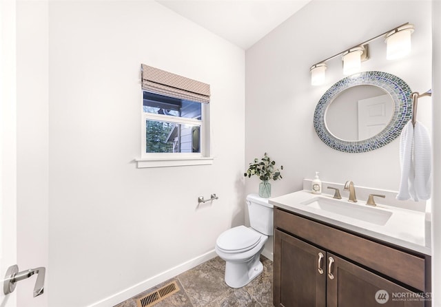 bathroom featuring toilet, baseboards, visible vents, and vanity