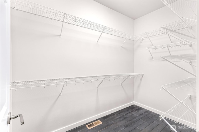 walk in closet featuring dark wood finished floors and visible vents