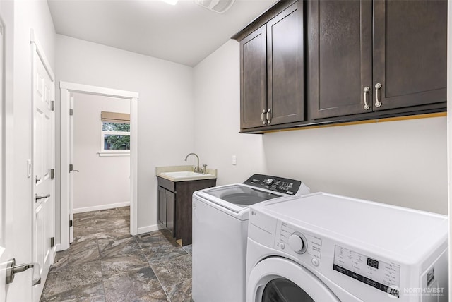 laundry area with washing machine and dryer, a sink, cabinet space, and baseboards