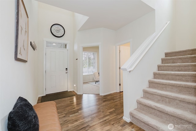 foyer entrance featuring stairway, baseboards, and wood finished floors