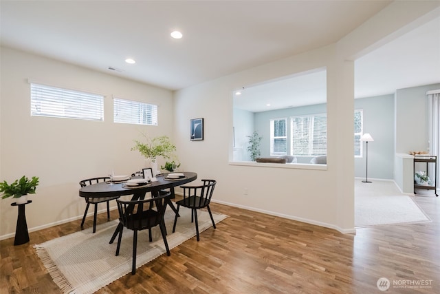 dining room featuring plenty of natural light, baseboards, wood finished floors, and recessed lighting