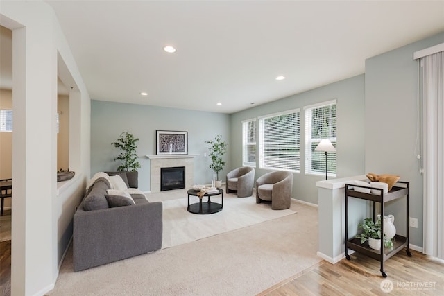 living area featuring a high end fireplace, wood finished floors, baseboards, and recessed lighting