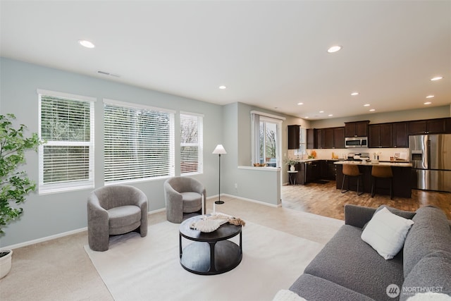 living room with baseboards, visible vents, and recessed lighting