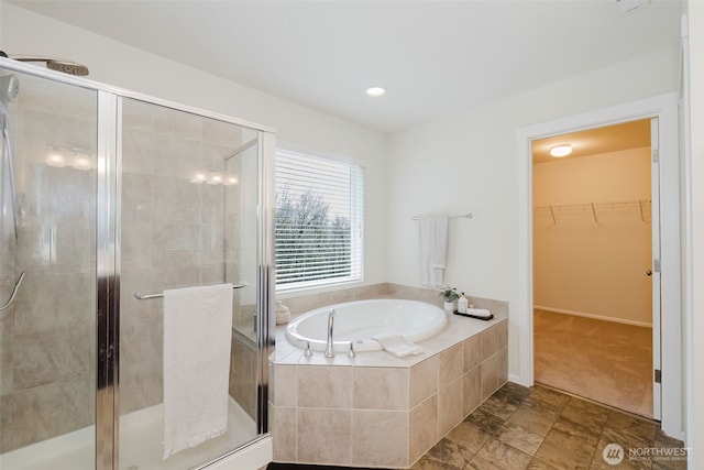 full bathroom featuring a stall shower, a spacious closet, and a bath