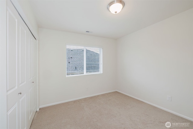 unfurnished bedroom with visible vents, baseboards, a closet, and carpet flooring