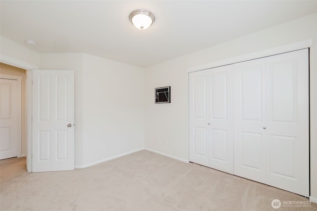 unfurnished bedroom featuring a closet, carpet, and baseboards