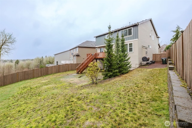 rear view of property with a deck, a fenced backyard, stairs, a lawn, and board and batten siding