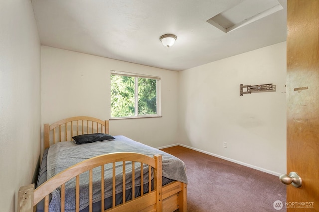 carpeted bedroom featuring attic access and baseboards