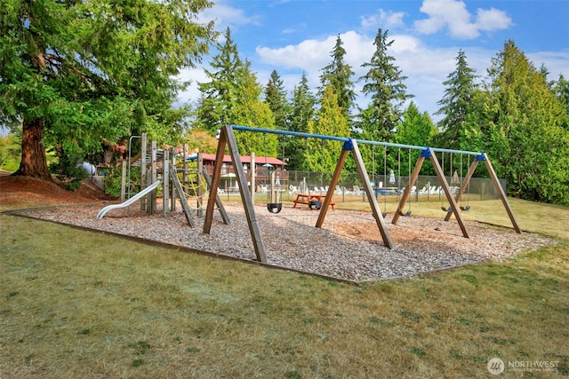 community jungle gym with a lawn and fence