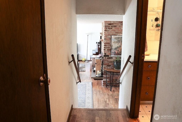 hall featuring an upstairs landing and wood finished floors