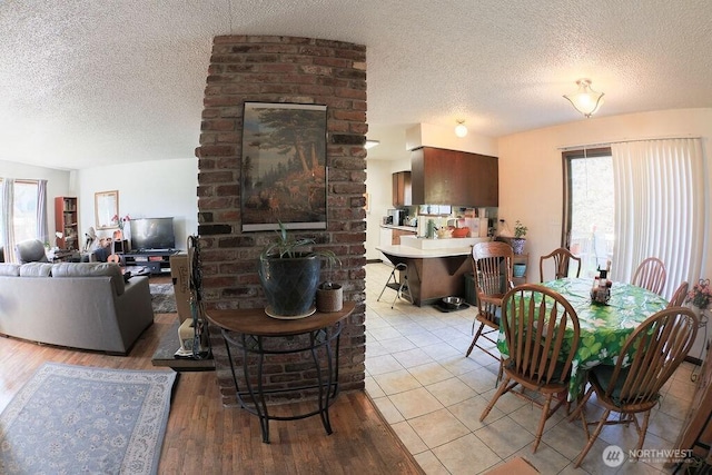 dining space featuring plenty of natural light, a textured ceiling, and light wood-style flooring