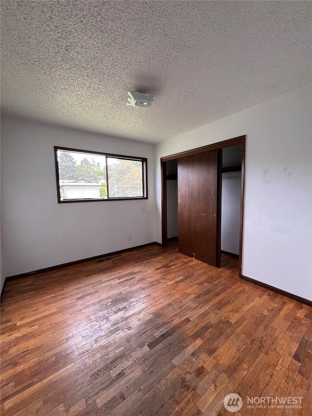 2109 Ontario St, Bellingham, WA 98229 - unfurnished bedroom featuring a closet, a textured ceiling, and wood finished floors