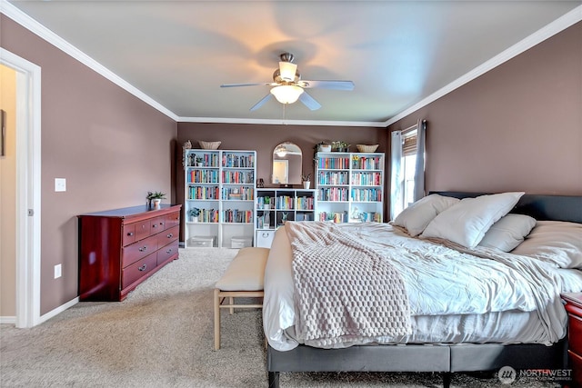 carpeted bedroom with ceiling fan, baseboards, and ornamental molding