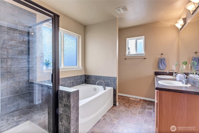 full bathroom featuring a sink, double vanity, a bath, and a shower stall