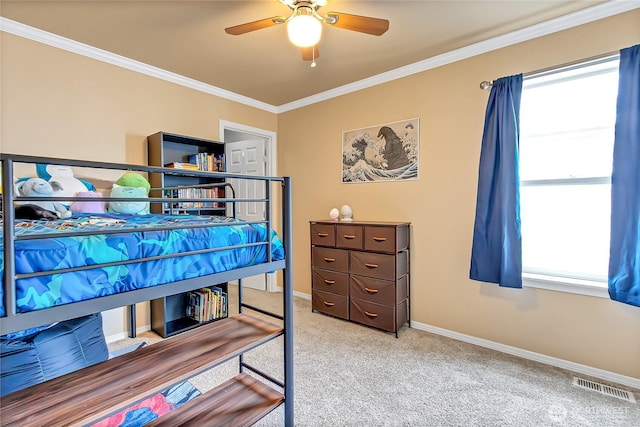 carpeted bedroom featuring a ceiling fan, baseboards, visible vents, and ornamental molding