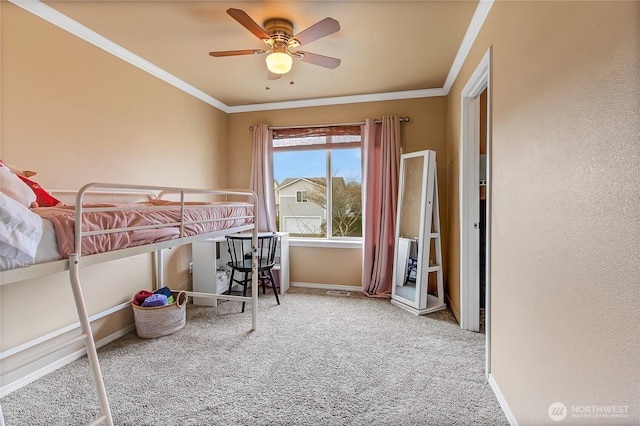 carpeted bedroom featuring a ceiling fan, baseboards, and ornamental molding