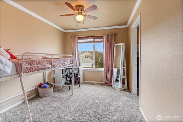 carpeted bedroom featuring a ceiling fan, baseboards, and ornamental molding