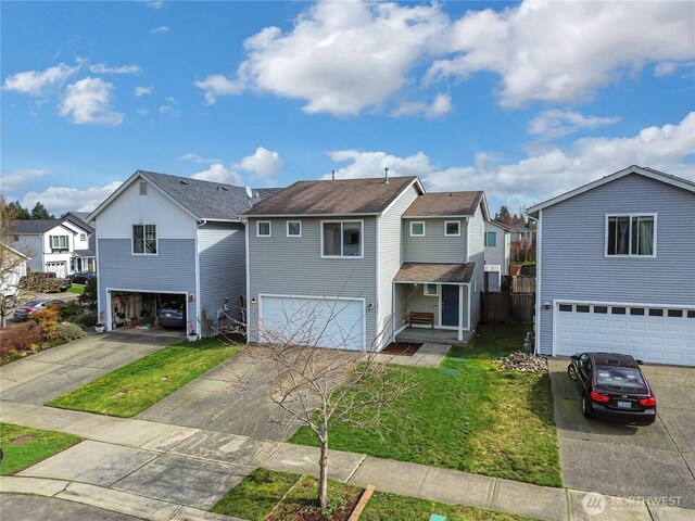 traditional-style home with a residential view, concrete driveway, and a front lawn