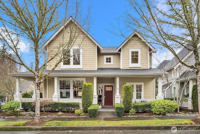 craftsman inspired home with covered porch and a shingled roof