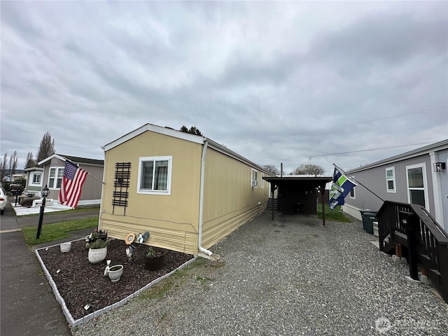 view of side of home featuring gravel driveway