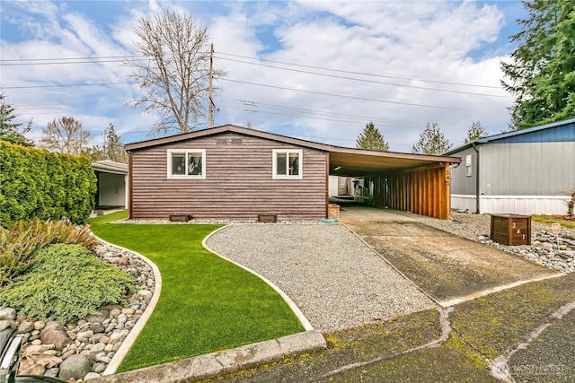 view of front of home featuring driveway, a front lawn, and an attached carport