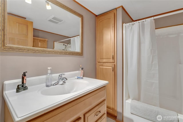 bathroom with shower / bathtub combination with curtain, visible vents, and vanity