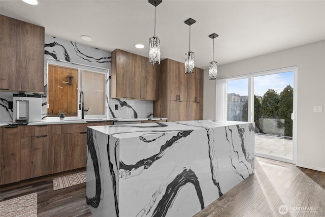 kitchen featuring dark wood-style floors, hanging light fixtures, and a center island