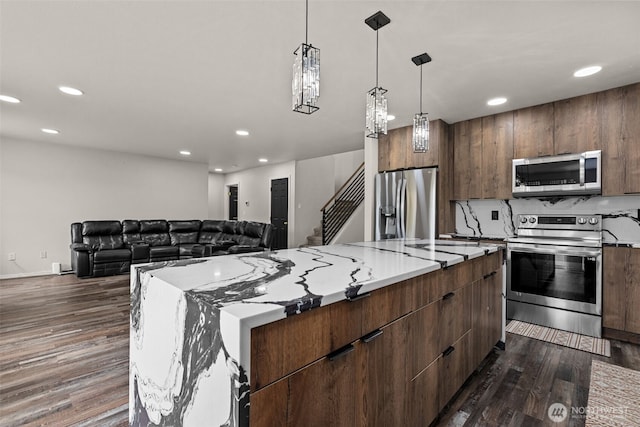 kitchen with stainless steel appliances, dark wood-type flooring, modern cabinets, and a kitchen island