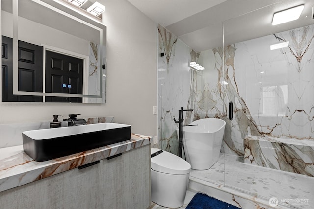 bathroom with toilet, a freestanding tub, a marble finish shower, and vanity