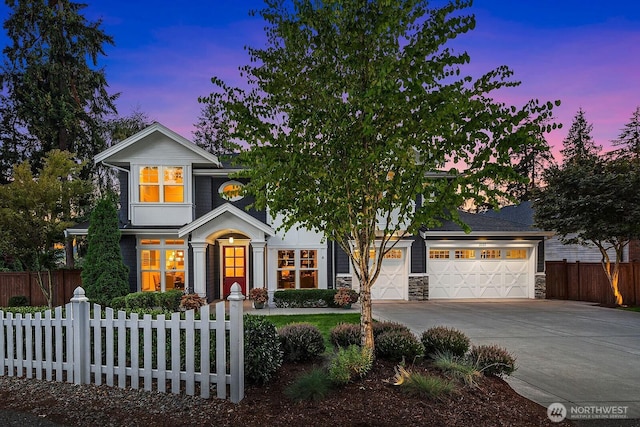 view of front facade with driveway, an attached garage, and stone siding