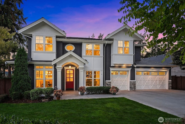 traditional-style house featuring driveway, stone siding, and an attached garage