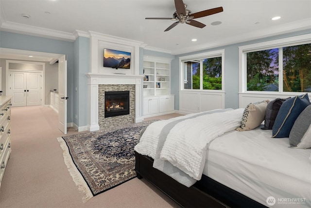bedroom with baseboards, recessed lighting, light carpet, ornamental molding, and a stone fireplace